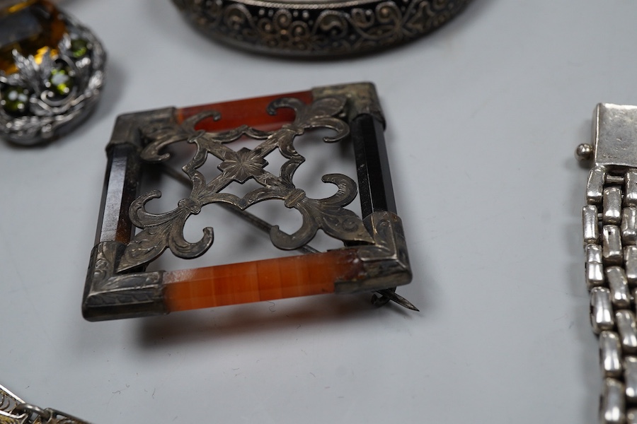 A group of silver jewels, comprising: a Scottish hardstone brooch of square outline; a pair of Arts and Crafts citrine and green tourmaline ear clips, length 2.7cm each; a silver link bracelet; a silver filigree bracelet